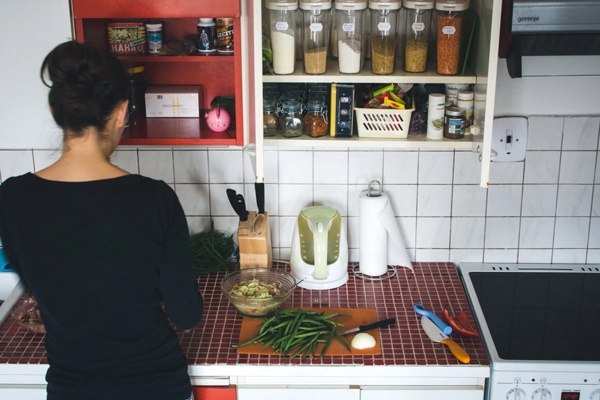 Persona cocinando en una cocina con estantes organizados