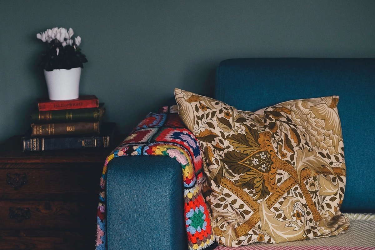 Sofá con almohadones y mantas en un living acogedor