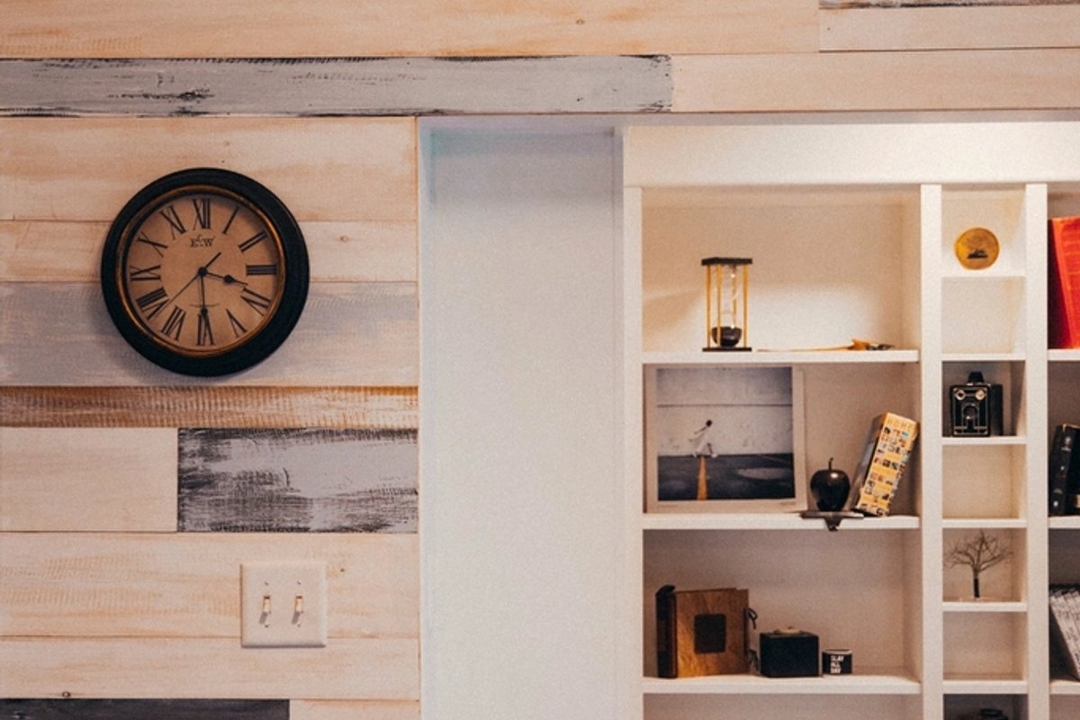 Estantería blanca prolija con objetos ordenados y reloj de pared